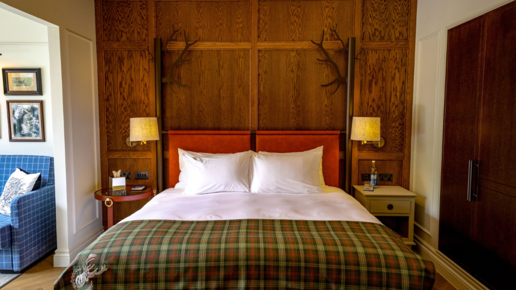 Bedroom at Seaton House St Andrews with tartan throw, wooden panelled wall and plush double bed.