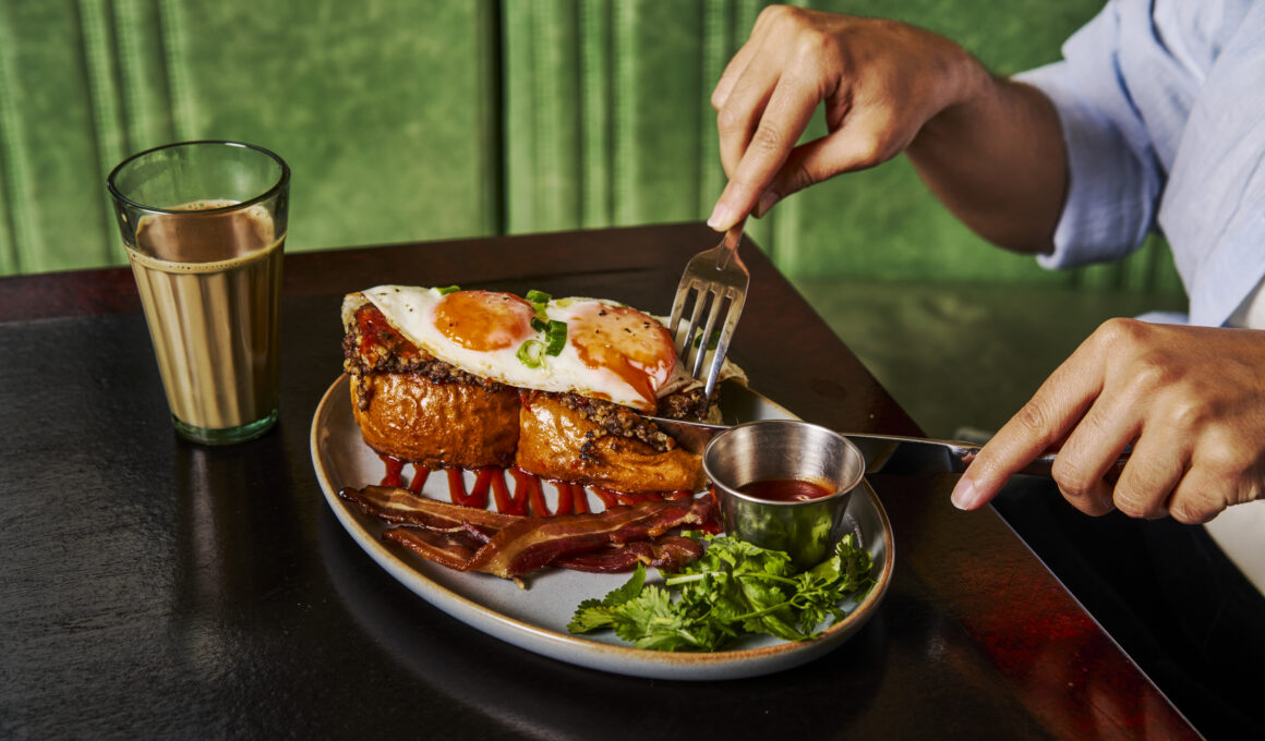 Haggis Pau breakfast special at Dishoom with pork haggis on buttered buns, fried eggs, bacon rashers, chilli chutney, cream cheese and coriander.