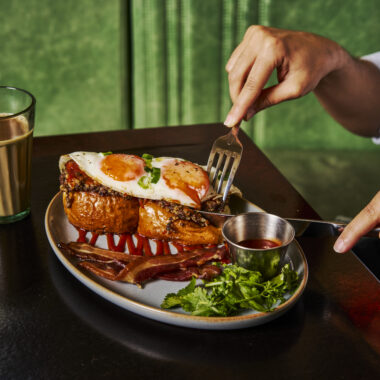 Haggis Pau breakfast special at Dishoom with pork haggis on buttered buns, fried eggs, bacon rashers, chilli chutney, cream cheese and coriander.
