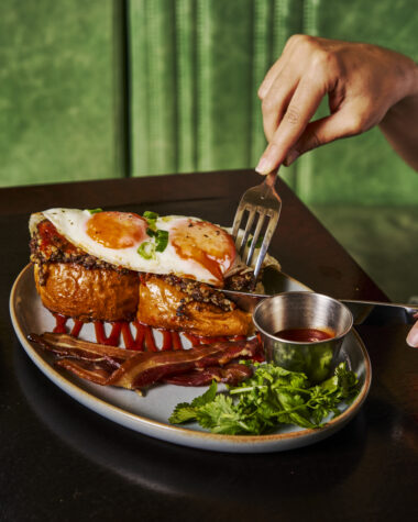 Haggis Pau breakfast special at Dishoom with pork haggis on buttered buns, fried eggs, bacon rashers, chilli chutney, cream cheese and coriander.